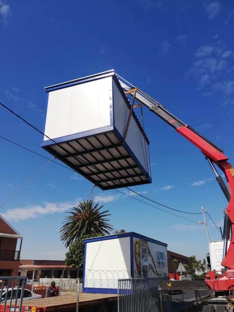 Mobile classroom unit lifted overhead by an AGA Transport crane truck