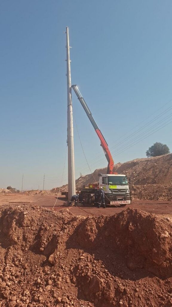 AGA Transport crane truck erecting a steel pole on a mining site